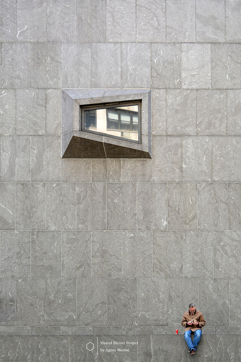 Whitney Museum iconic trapezoid window detail on stone wall with a man