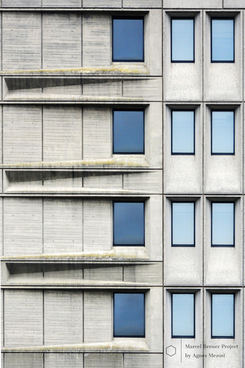 Close-up color photograph of a vertical section of the building's facade, showing windows set in deep concrete frames.