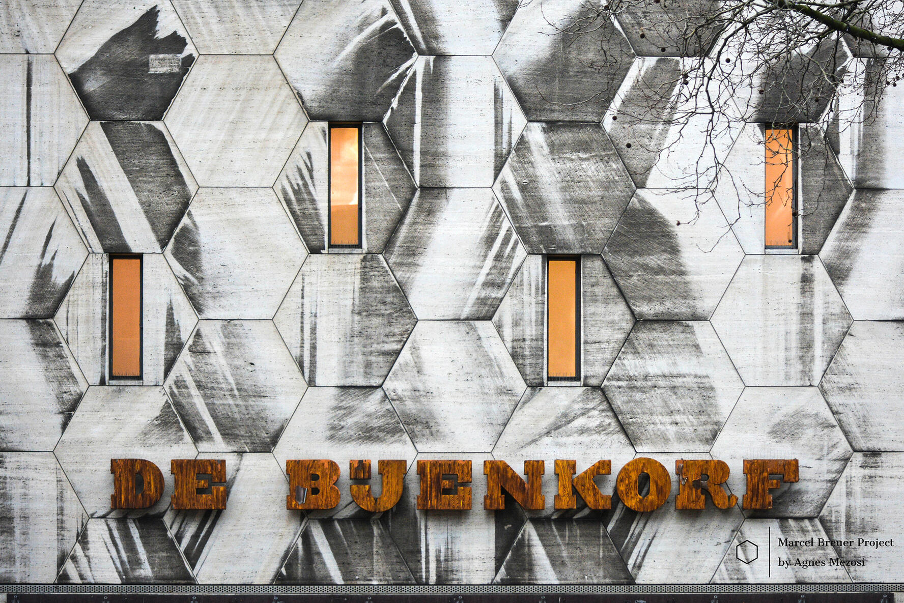 the store's name in 3D wooden letters mounted on the iconic hexagonal-patterned travertine wall.