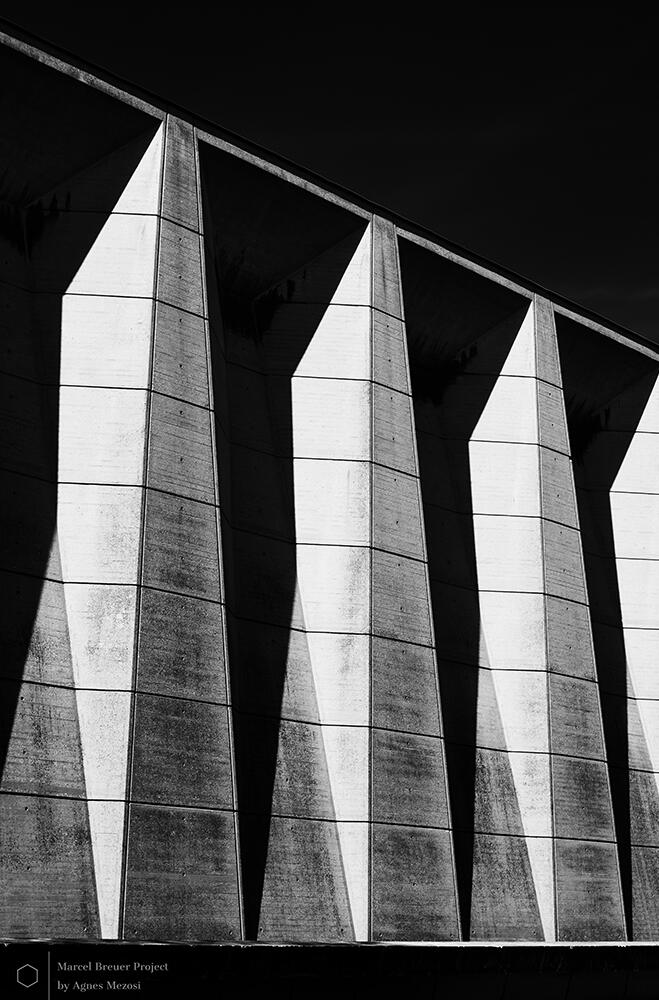 Abstract architectural shots of the UNESCO building's exterior, focusing on the sharp, vertical concrete fins and the deep shadows cast by the Parisian sun.