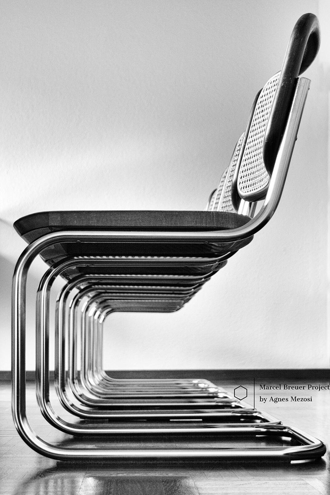Cesca chairs Close-up photograph of a Marcel Breuer designed Cesca chair, emphasizing its geometric lines, tubular steel frame, and cane seat against a dark background, showcasing a minimalist aesthetic.